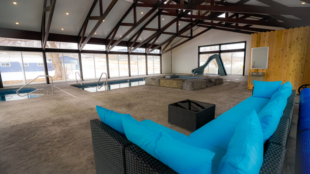 Image of indoor pool with waterslide and seating area, perfect fun for a corporate event.