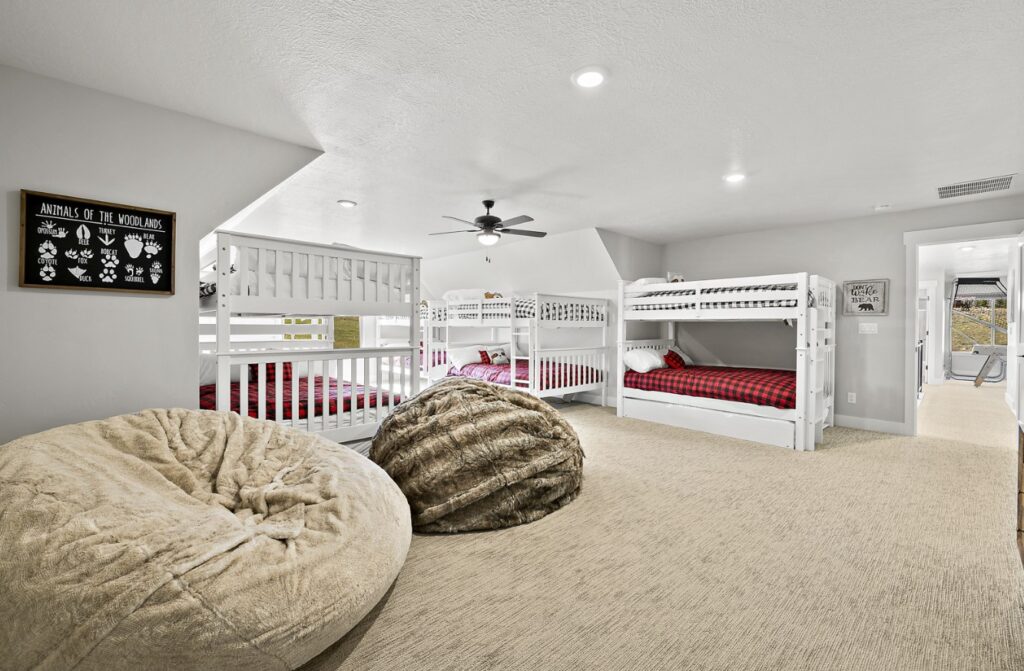 Bedroom with multiple bunk beds and large bean bag style chairs.
