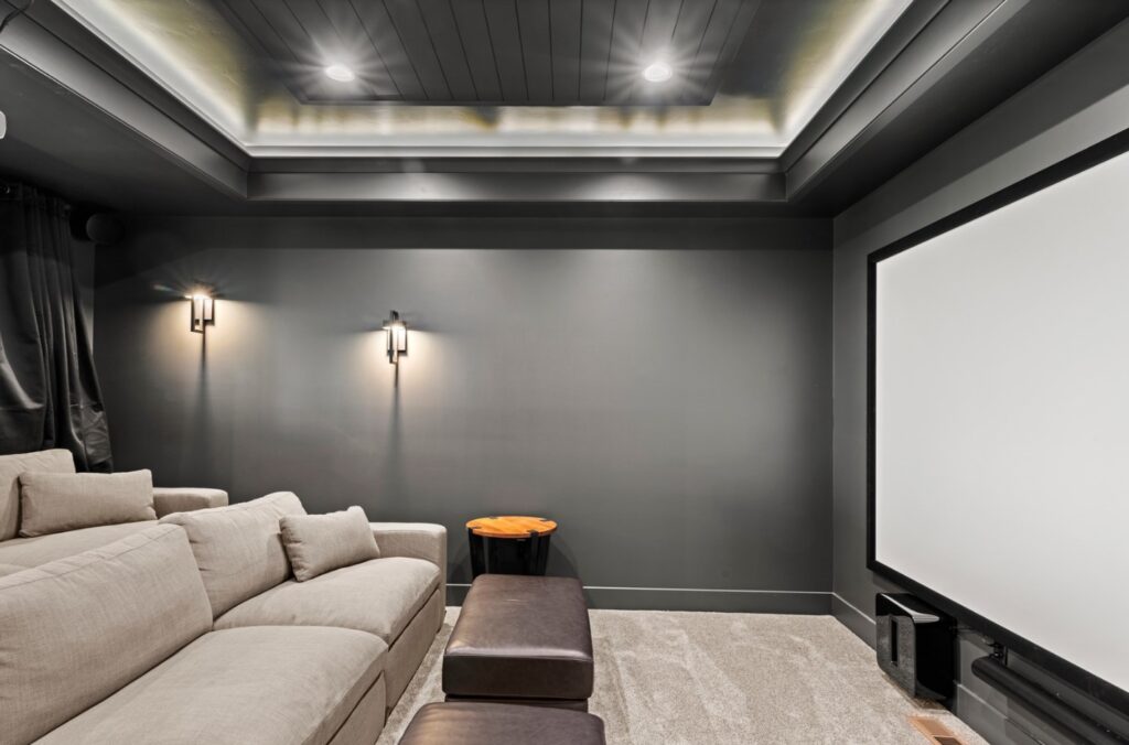 Home theater with stadium-style elevated seating and 100 inch projection screen