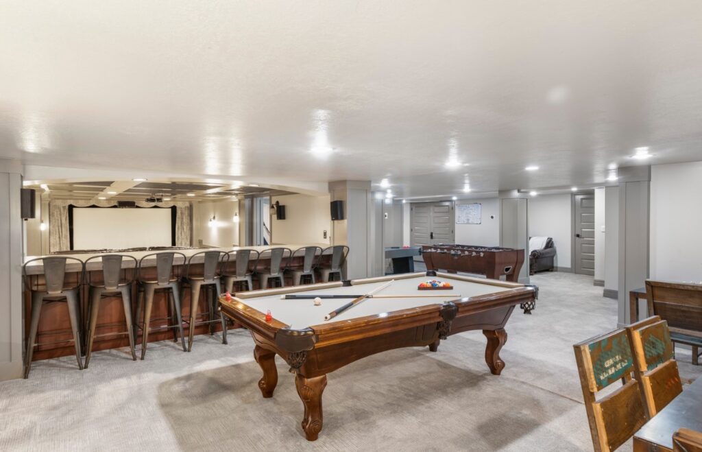 Basement games floor showcasing foosball, pool table, and home theater amenities.