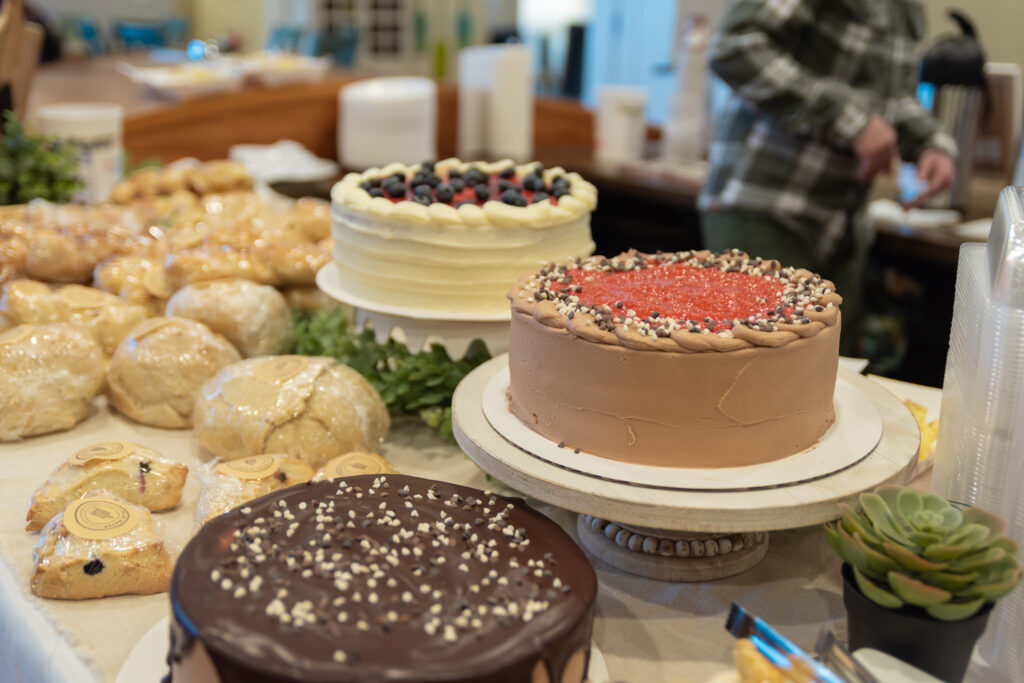 Chocolate and vanilla cakes, with other baked desert goods on a table.