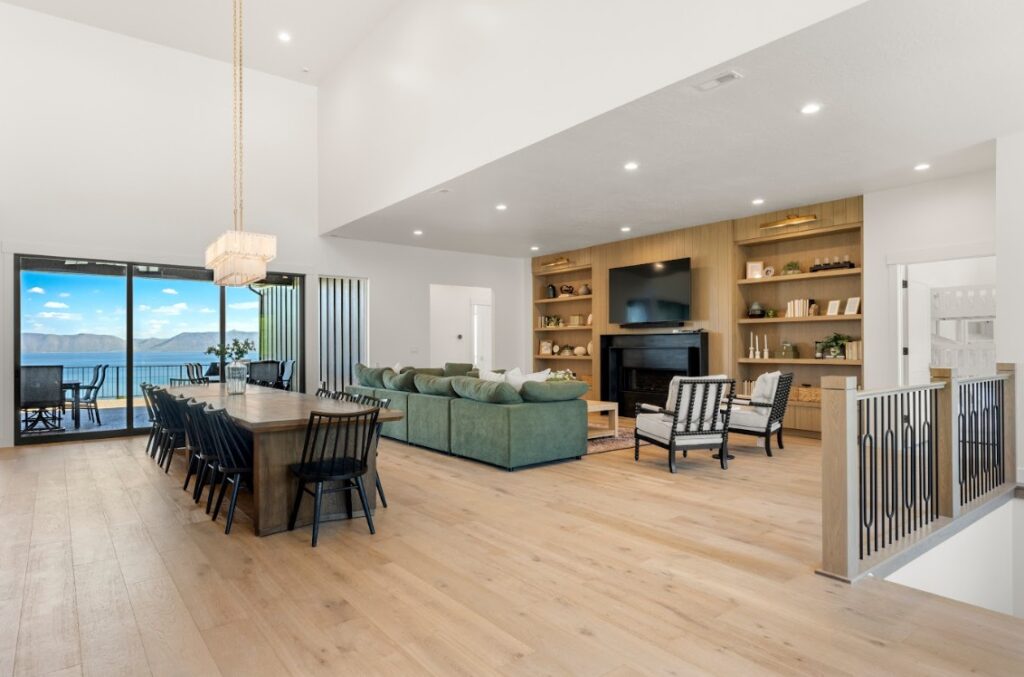 Emerald Estate's family room with long dining table and TV overlooking Bear Lake.